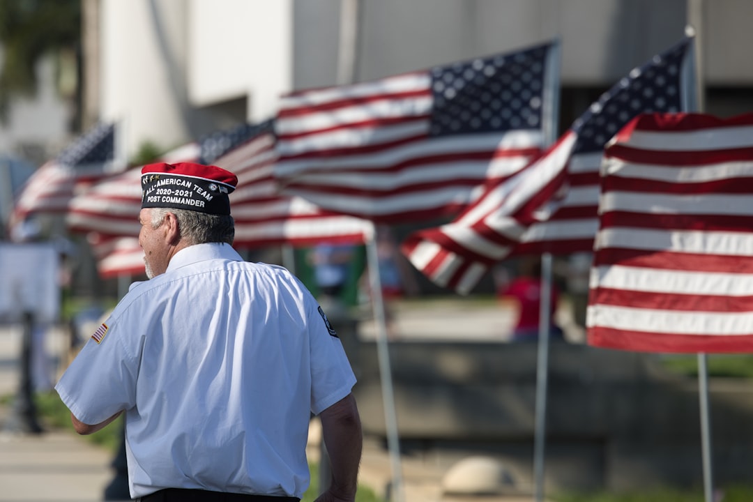 a man standing in front of a row of american flags