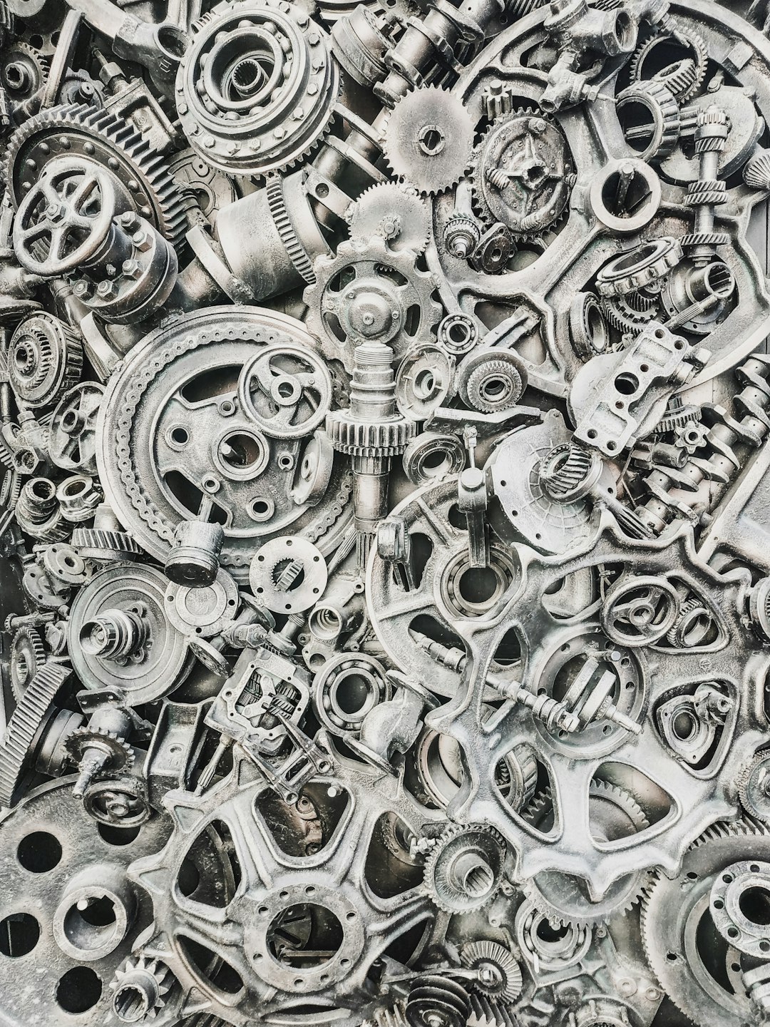 A dense collection of assorted metal gears, cogs, and mechanical machine parts